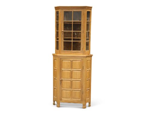 BOB HUNTER, A WRENMAN OAK STANDING CORNER CUPBOARD, CIRCA 1980S the upper section with a glazed door and sides, enclosing two