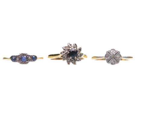 THREE GEM-SET RINGS comprising a sapphire and diamond cluster ring, marked '18CT', ring size L; a diamond cluster ring, marke