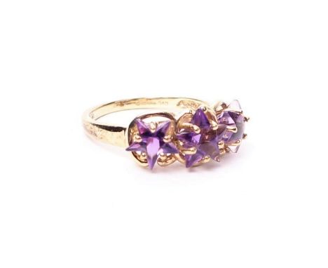 A 9ct gold three-stone amethyst dress ring, set with three graduated star cut amethysts.