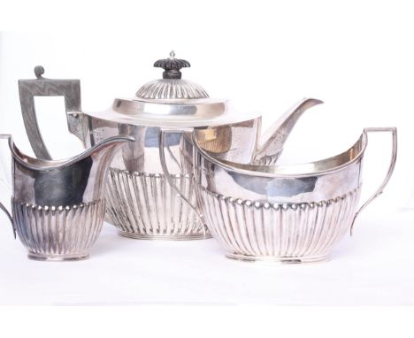 A three piece sterling silver tea set, with half reeded decoration and ebony handle, tea pot by Mappin &amp; Webb, Sheffield 