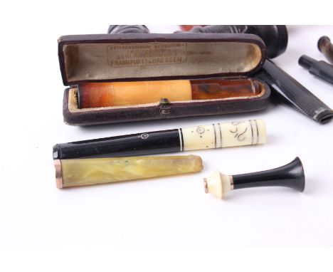 A boxed amber and meerschaum cheroot holder, and an inlaid ivory cheroot holder; together with assorted pipe stems and bowls 