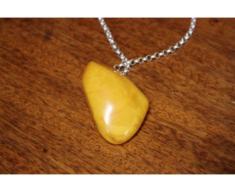 A large honey amber pendant, suspended from a sterling silver belcher link chain, 64g gross. 