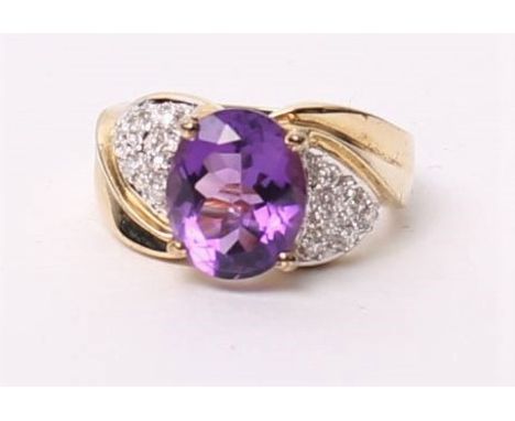 A 9ct gold amethyst and diamond dress ring, the central oval cut amethyst in a four claw setting with single cut diamond shou