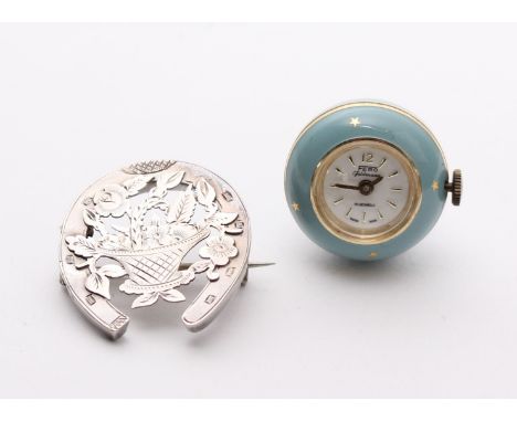 A small globe watch in unmarked yellow metal and blue enamel case; together with a sterling silver horse shoe brooch (2).