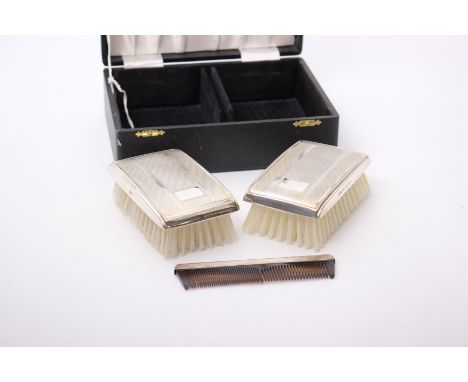 A boxed set of sterling silver clothes brushes, with engine turned decoration with matching silver mounted comb, by W.I. Broa