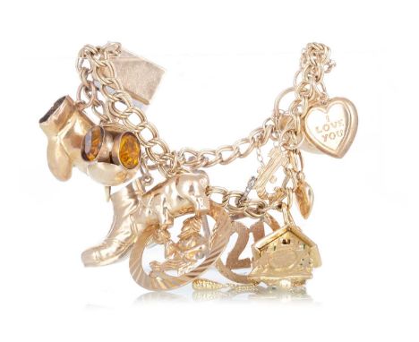 CHARM BRACELET AND A GROUP OF LOOSE CHARMS in nine carat gold, with appendages including a cuckoo clock, and five loose charm