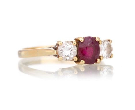 RUBY AND DIAMOND THREE STONE RING set with an oval ruby flanked by diamonds totalling approximately 0.60 carats, unmarked, si