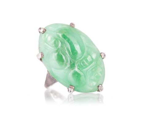 JADE RING  set with a carved oval stone, in unmarked white metal, size K  Qty: 8.6g  Generally worn. Sizing balls on shank. M