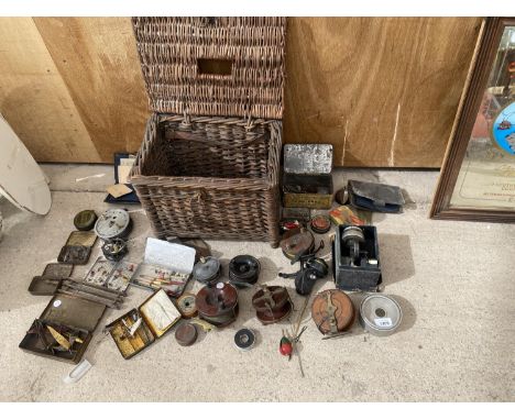 A VINTAGE WICKER BASKET WITH A LARGE COLLECTION OF FISHING TACKLE TO INCLUDE REELS, LURES AND FLOATS ETC 