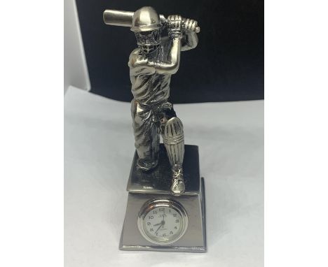 A HEAVY WHITE METAL CRICKET TROPHY WITH A CLOCK FACE IN WORKOING ORDER 