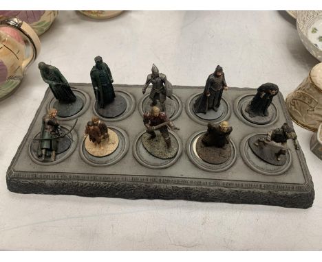 A COLLECTION OF TEN LORD OF THE RINGS FIGURES ON A DISPLAY STAND 