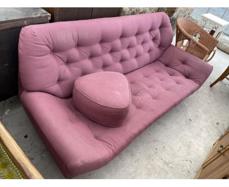A 1970'S STYLE BUTTON BACK SETTEE WITH LOW RAKING ARMS AND MATCHING POUFFE 