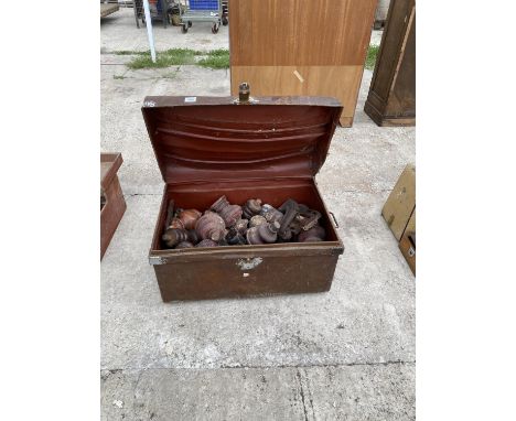 A VINTAGE TIN TRUNK CONTAINING TURNED FURNITURE FEET AND STAIR TOPS 