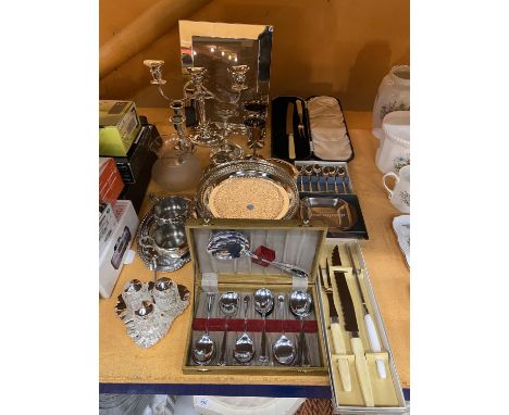 A LARGE QUANTITY OF SILVER PLATED TABLEWARE TO INCLUDE SEVERAL CANDLE STICK HOLDERS, TWO CARVING SETS AND A DECORATIVE SERVIN