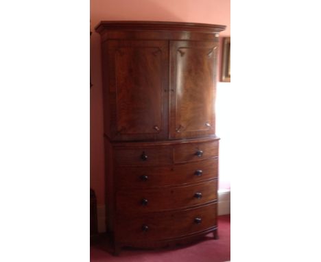 A VICTORIAN MAHOGANY BOW FRONTED LINEN PRESS With moulded cornice above framed panelled doors, enclosing slides with two shor