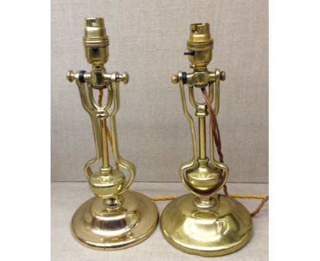 TWO EARLY 20TH CENTURY HEAVY BRASS CANDLESTICK LAMPS One with movable pivot (electrified)