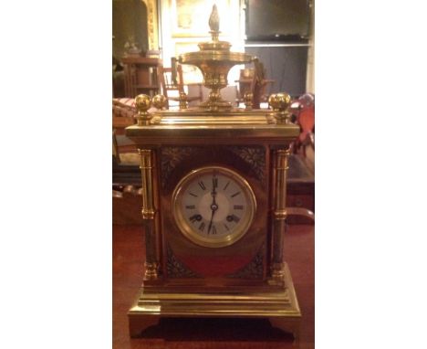 A LATE 19TH CENTURY FRENCH MANTLE CLOCK The gilt metal case mounted with a two handled urn, having an engine turned dial and 