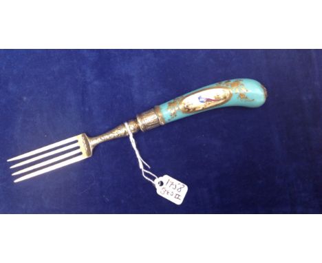 AN 18TH CENTURY PORCELAIN HANDLED FORK The pistol grip handle decorated with an exotic bird in a gilded cartouche on turquois