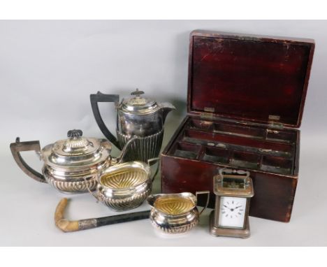 An early 20th century plated brass cased carriage timepiece, 14cm high, a three-piece electroplate tea service and a similar 