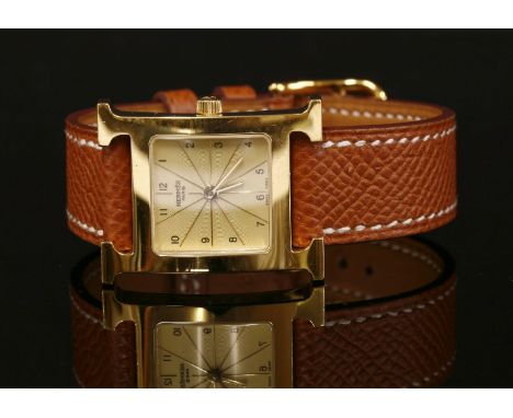 A ladies' gold plated Hermès Heure H quartz strap watch. Model no. HH1.201.  Square engine turned champagne dial with black A