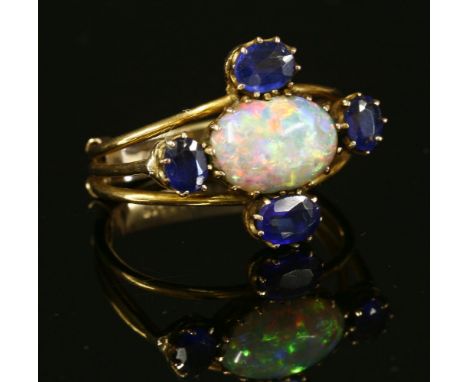 An Edwardian opal and doublet cinquefoil cluster ring,with an oval cabochon opal, claw set to the centre in a landscape posit