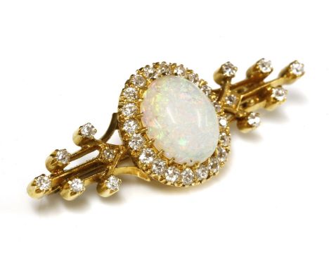 A late Victorian opal and diamond bar brooch, c.1895,with a central opal and diamond cluster.  An oval cabochon opal, claw se