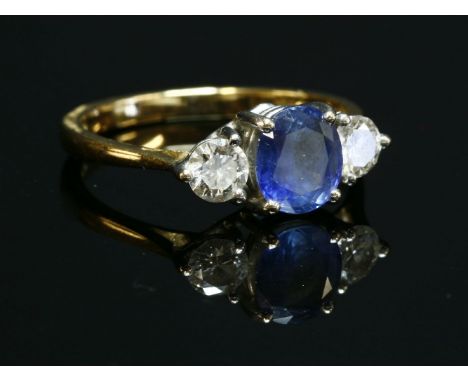 An 18ct gold sapphire and diamond three stone ring,with an oval mixed cut sapphire, four claw set to the centre.  A brilliant