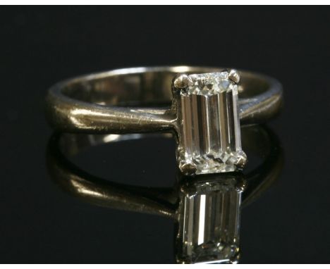 A single stone diamond ring,with an emerald cut diamond, estimated as approximately 0.80ct, four claw set in a plain collet, 