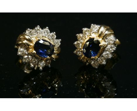 A pair of two colour gold, sapphire and diamond oval cluster earrings,with an oval mixed sapphire, four claw set to the centr