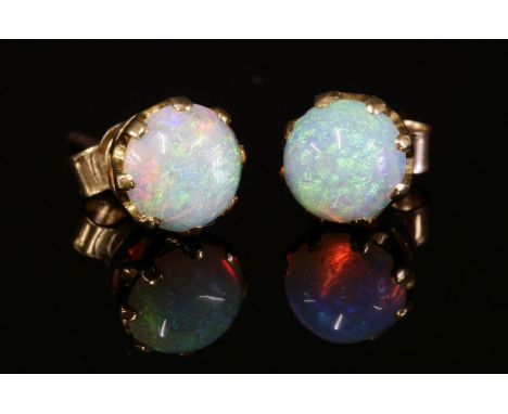 A pair of single stone opal stud earrings, with a circular cabochon opal, claw set to a rex collet, with later post and butte