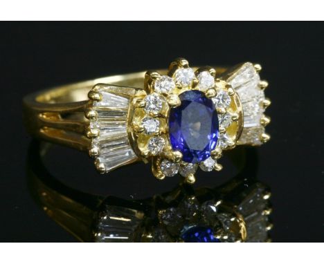 An 18ct gold sapphire and diamond cluster ring with bow-shaped shoulders, a central oval mixed cut sapphire, with a stated we