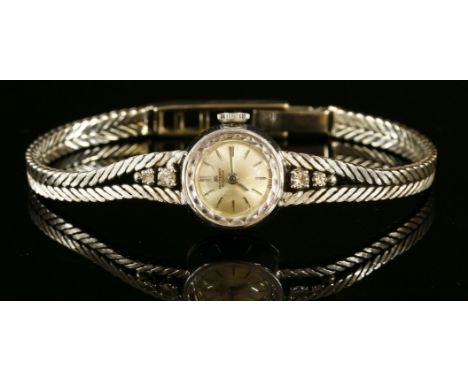 A ladies' 18ct white gold, diamond set, Bucherer mechanical bracelet watch, c.1960,with a circular silvered dial with raised 