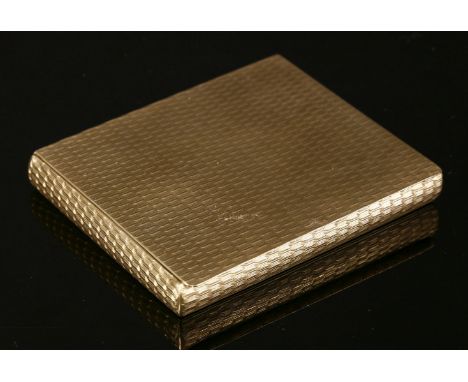 A 9ct gold compact,of rectangular form with engine turned decoration to all sides.  Overhanging thumbpiece with interior mirr