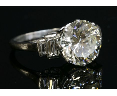 A single stone diamond ring with stepped baguette cut diamond shoulders, c.1925,a brilliant cut diamond, estimated as approxi