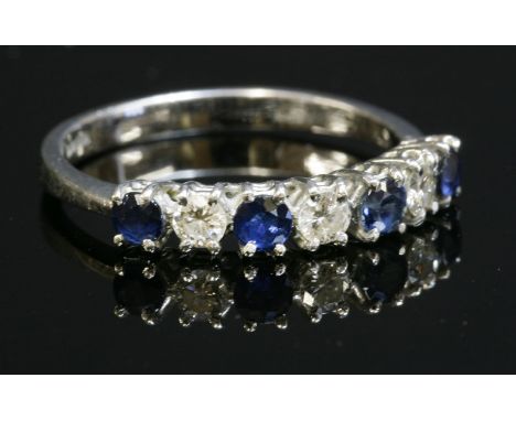 An 18ct white gold, sapphire and diamond half hoop ring,with alternate circular mixed cut sapphires and brilliant cut diamond