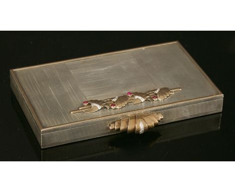 A French silver, gold, ruby and diamond minaudière, c.1930,by Ostertag of Paris.  Silver rectangular hinged form with raised 