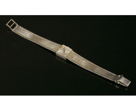 A ladies' 9ct white gold Tissot mechanical bracelet watch,with a square case, silvered dial and black raised batons and hands