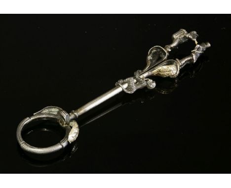 A French novelty silver and gold ring style cigarette holder, c.1900,of textured vine or twig form.  Two cast silver monkeys,