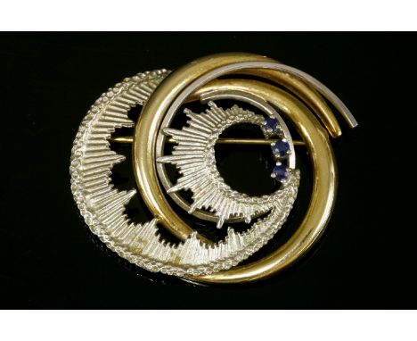 A yellow and white gold sapphire scrolling brooch, c.1960, a polished crescent to an incised white spray with three round cut