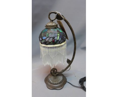 A Tiffany style table lamp, raised on floral base and having butterfly shade with glass tassels. H-50cm 