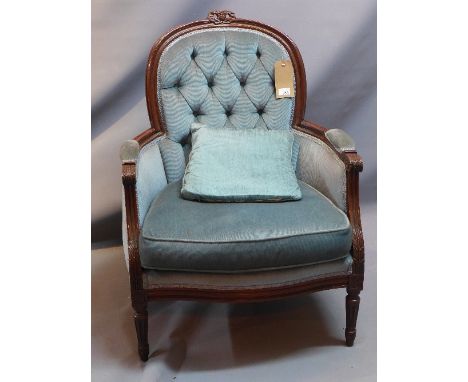 An early 20th Century French oak arm chair with blue button back velour upholstery, raised on reeded legs. 