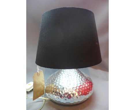 A Contemporary chrome table lamp, of squat form with dimpled decoration, having black shade, H. 44cm