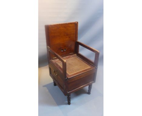 An early 20th Century mahogany campaign commode, raised on turned legs. 
