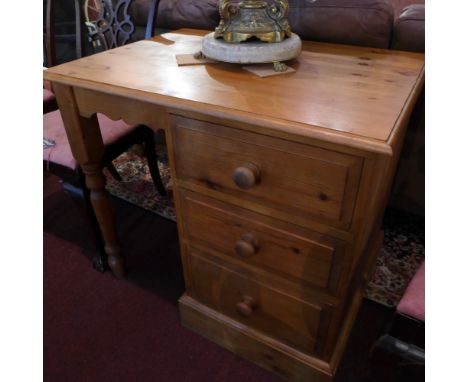 A pine kneehole desk having three small drawers, raised on turned legs. H-74cm, W-84cm, D-60cm 