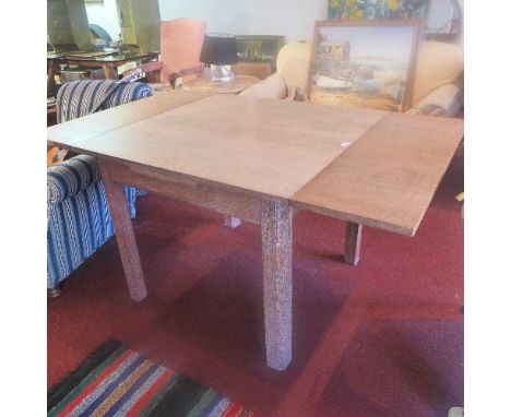 A 1930s Heals limed oak draw leaf dining table, inset with Heals button