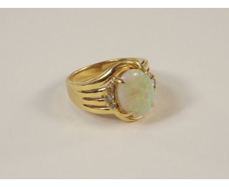 OPAL RING. An 18k. hand made ring, set a large opal of good colour &amp; six small brilliant cut diamonds. Size M/N.