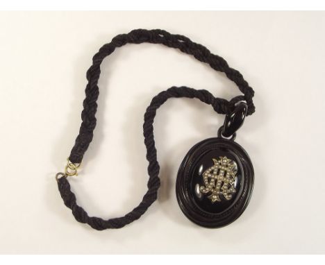 VICTORIAN LOCKET.A Victorian composition locket, the front with seed pearl monogram, the reverse a photograph compartment, on