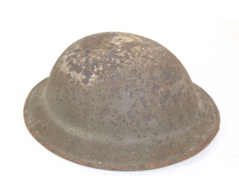 A WWI era British Brodie helmet with original lining, but in overall relic condition 