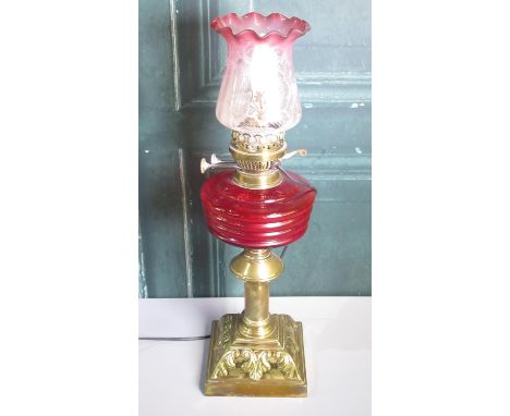 20th century brass oil lamp, with red glass reservoir and cranberry tint etched shade, now converted to electricity, H53m 