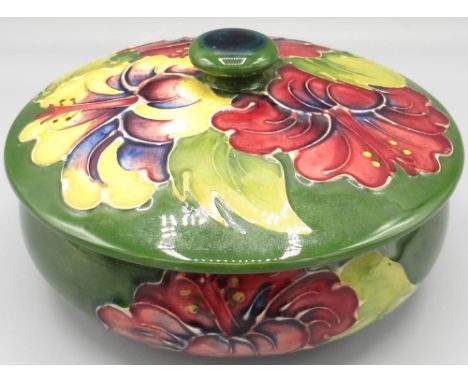 Moorcroft Pottery: 'Hibiscus' pattern circular trinket pot and cover, purple and yellow flowers on green ground, D12cm 